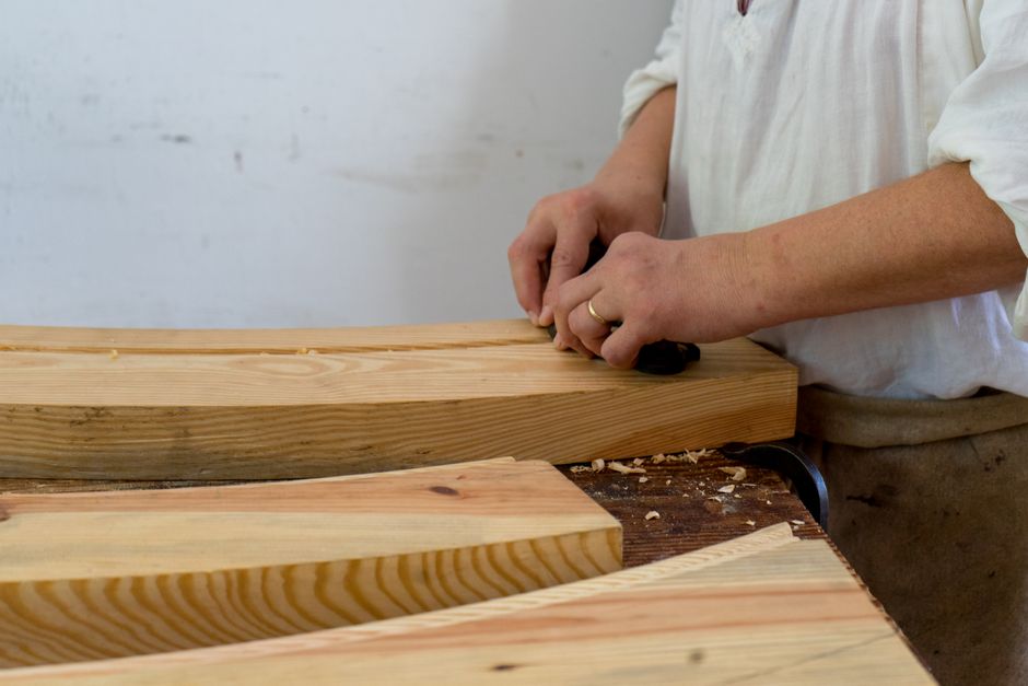 Woodworker meticulously crafting a piece in the workshop